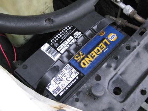 1991 Ford LTD Crown Victoria - A car battery is visible in the engine bay, with various labels and warnings.