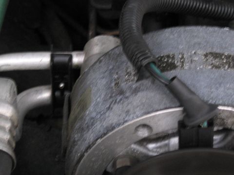1991 Ford LTD Crown Victoria - Detail of an AC compressor, showing hoses and electrical connections.