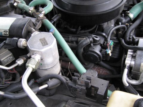 1991 Ford LTD Crown Victoria - Close-up view of an engine bay, focusing on various mechanical components and hoses.