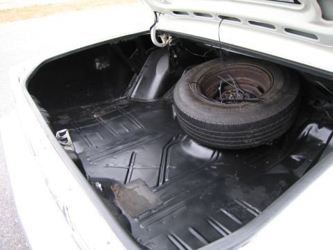 1991 Ford LTD Crown Victoria - The trunk of a car is shown, containing a spare tire and showing signs of wear and tear.
