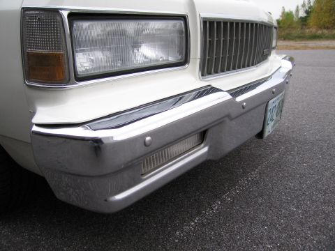 1991 Ford LTD Crown Victoria - The chrome grille and rectangular headlight assembly are characteristic of a 1990s Chevrolet Caprice.