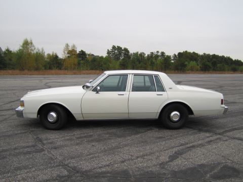 1991 Ford LTD Crown Victoria - Side view of a white sedan, possibly a Chevrolet Caprice, parked outdoors.