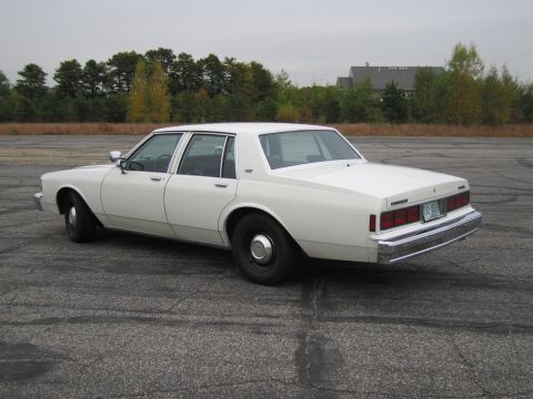 1991 Ford LTD Crown Victoria - This white sedan has a classic boxy body style and chrome bumper details.