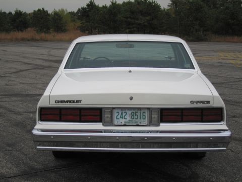 1991 Ford LTD Crown Victoria - Rear view of a white Chevrolet Caprice sedan parked outdoors on an asphalt surface.