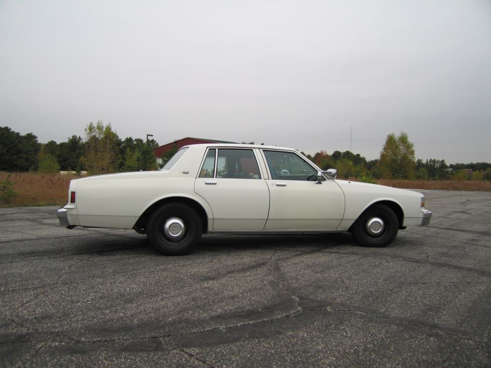 White 1991 sedan, side view. Appears to be a Chevrolet Caprice