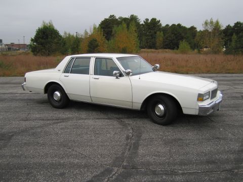 1991 Ford LTD Crown Victoria - This white sedan, likely from the 1980s, does not match the registry's claim of a 1991 Ford Crown Victoria LTD.