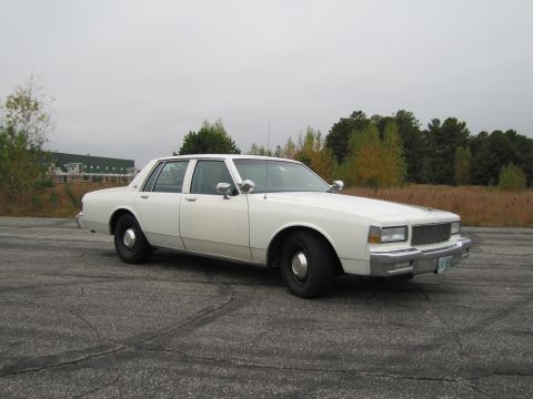 1991 Ford LTD Crown Victoria - This white sedan, likely from the 1980s, does not match the registry's claim of a 1991 Ford Crown Victoria LTD.