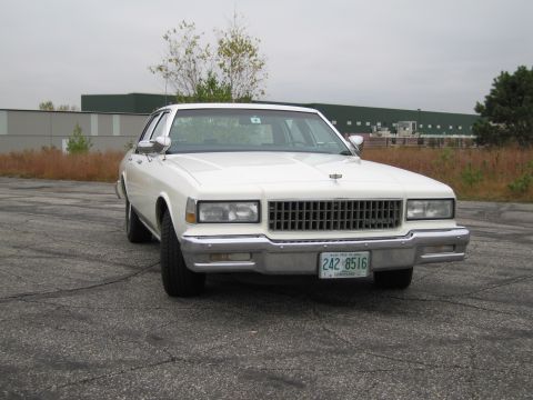 1991 Ford LTD Crown Victoria - This white 1990 Chevrolet Caprice sedan is shown from the front, its distinctive chrome grille and a clear license plate.