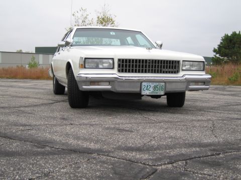 1991 Ford LTD Crown Victoria - Front view of a white 1986 Chevrolet Caprice parked on cracked asphalt.