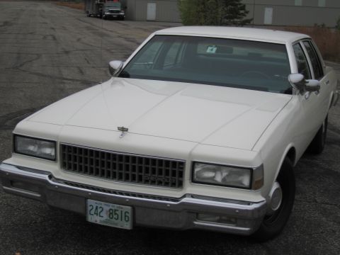 1991 Ford LTD Crown Victoria - This 1980s Chevrolet Caprice sedan is parked outdoors on an asphalt lot.