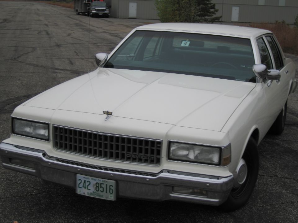 White Chevrolet Caprice sedan, front view. License plate reads 242 8516