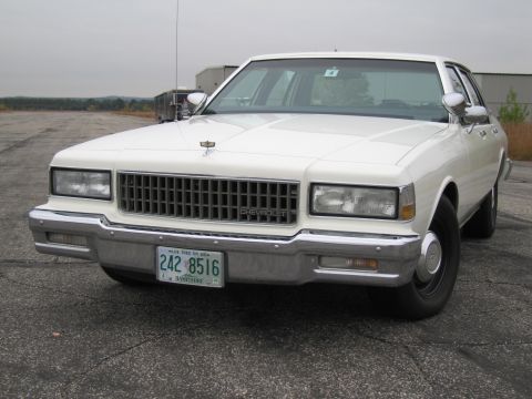 1991 Ford LTD Crown Victoria - This white Chevrolet Caprice sedan features a prominent chrome grille and a front view.