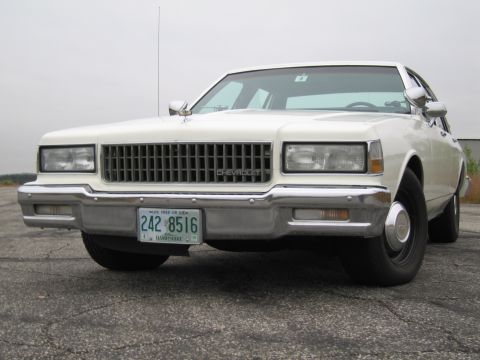 1991 Ford LTD Crown Victoria - This white Chevrolet Caprice sedan is shown from the front, a prominent grille and license plate.