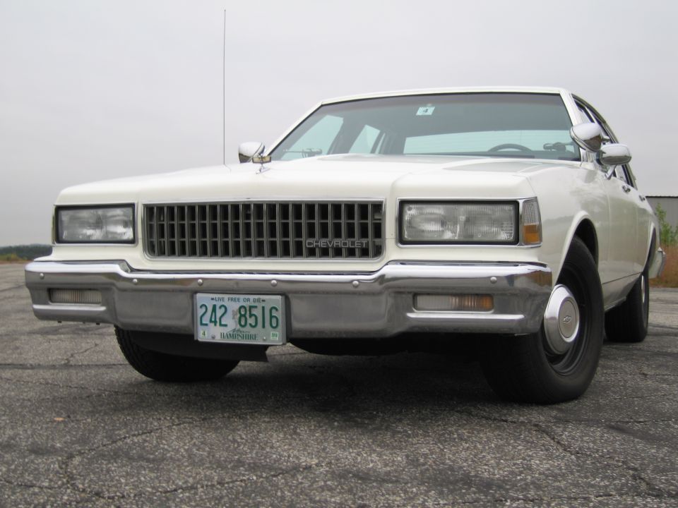 White Chevrolet Caprice sedan front view with license plate 242 8516