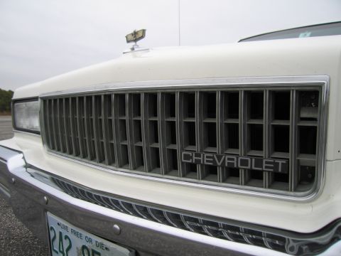 1991 Ford LTD Crown Victoria - The front grille of a Chevrolet, the brand nameplate and a hood ornament.