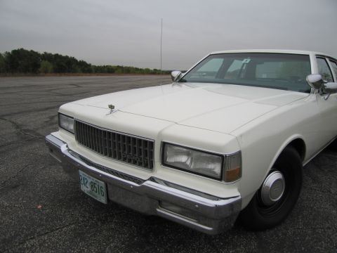 1991 Ford LTD Crown Victoria - White 1991 Chevrolet Caprice sedan shown from the front 3/4 angle. The license plate reads 242 8516.