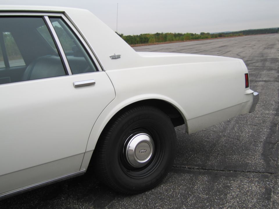 White sedan rear quarter panel and wheel