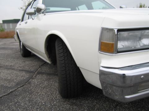 1991 Ford LTD Crown Victoria - This white sedan's body style suggests a 1990 model year, contradicting the registry's claim.
