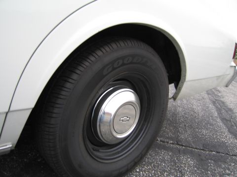 1991 Ford LTD Crown Victoria - Rear wheel and hubcap of a white vehicle, a Chevrolet emblem.