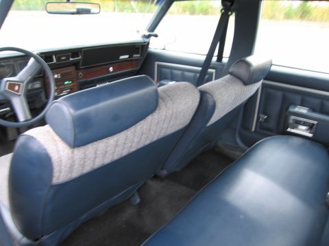 1991 Ford LTD Crown Victoria - Interior view of a car with blue cloth and vinyl seats, and a wood-grain dashboard.