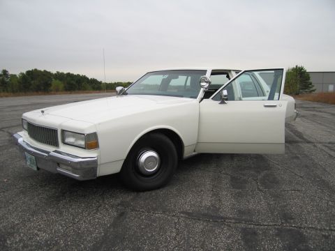 1991 Ford LTD Crown Victoria - This 1990 Chevrolet Caprice sedan is shown from the front-three-quarter angle with the driver's side door ajar.