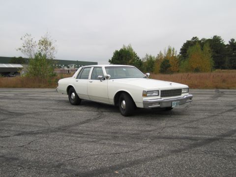 1991 Ford LTD Crown Victoria - This white sedan appears to be a Chevrolet Caprice from the 1980s, not a 1991 Ford Crown Victoria.