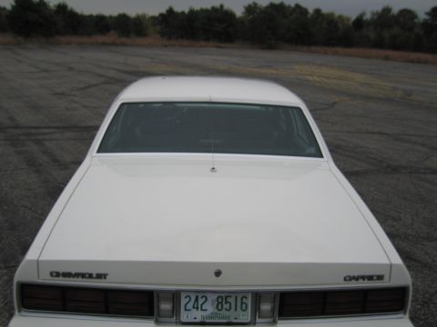 1991 Ford LTD Crown Victoria - This 1980s Chevrolet Caprice sedan is seen from the rear on an asphalt lot.