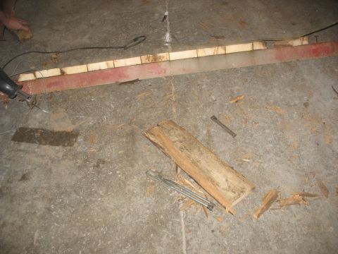 1900 Ford C-350 (Centurion Conversions) - Tools and wood debris are on a concrete floor, suggesting a construction or demolition project.