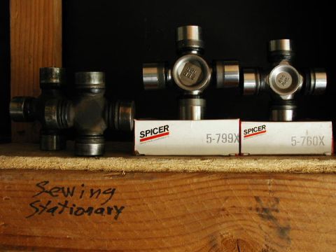 1995 Ford Bronco - Universal joints and their packaging are displayed on a wooden shelf.