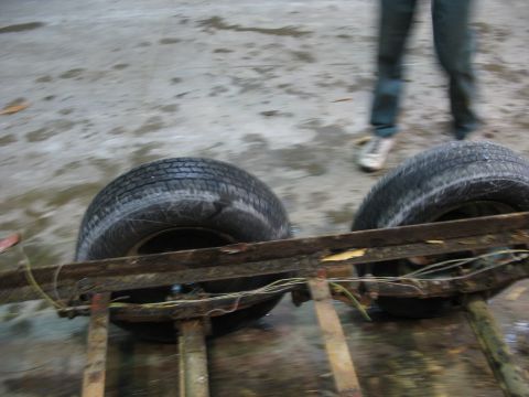 1900 Ford C-350 (Centurion Conversions) - The rusty frame of a trailer is visible with two tires attached.