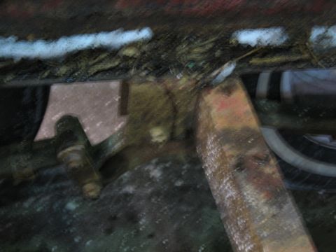 1900 Ford C-350 (Centurion Conversions) - Close-up view of a vehicle's undercarriage, showing suspension parts and accumulated debris.