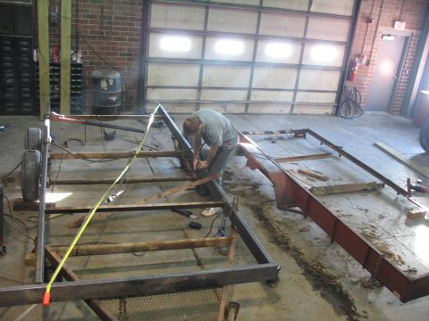 1900 Ford C-350 (Centurion Conversions) - Trailer frame construction in progress inside a garage or workshop.