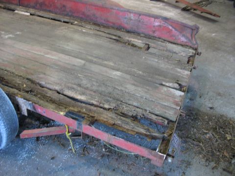 1900 Ford C-350 (Centurion Conversions) - The trailer bed shows significant wear and damage to its wooden planks and red metal frame.