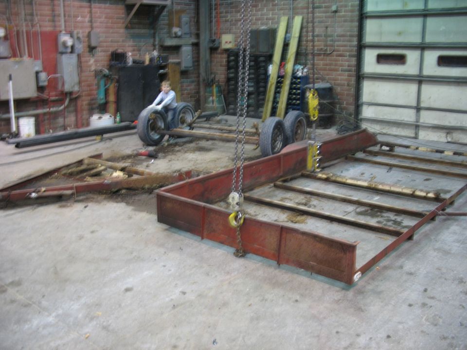 Trailer chassis with wheels and a person sitting on one wheel