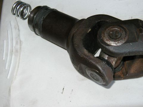 1995 Ford Bronco - Close-up of a driveshaft slip yoke assembly, showing a dislodged spring near the yoke.