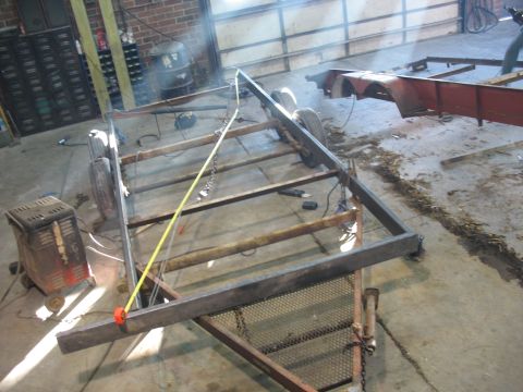 1900 Ford C-350 (Centurion Conversions) - Workshop scene showing a trailer frame under construction with welding equipment nearby.