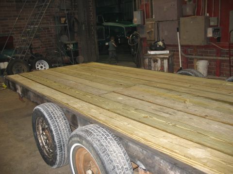 1900 Ford C-350 (Centurion Conversions) - Flatbed trailer with a wooden deck, interior garage scene with a truck visible.