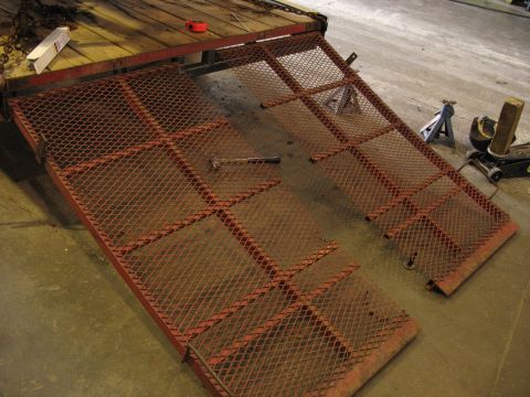 1900 Ford C-350 (Centurion Conversions) - Trailer ramps are shown deployed on a concrete floor, with a wooden trailer bed visible in the background.