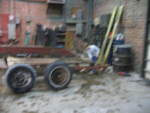 1900 Ford C-350 (Centurion Conversions) - Trailer chassis and wheels in a workshop setting with a person attending to it.