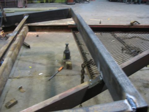 1900 Ford C-350 (Centurion Conversions) - Metal framework is under construction in a workshop setting, with tools and equipment visible.