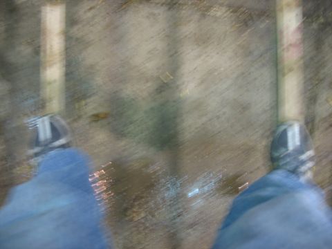 1900 Ford C-350 (Centurion Conversions) - A first-person perspective shows feet clad in jeans and sneakers standing on a wet, textured ground with reflections.