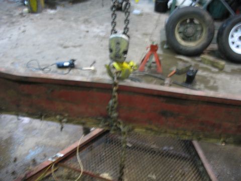 1900 Ford C-350 (Centurion Conversions) - Chain hoist and beam in a workshop setting, with spare tires and tools visible.