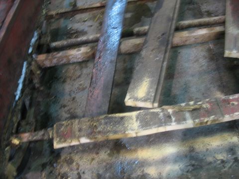 1900 Ford C-350 (Centurion Conversions) - The interior of a vehicle is filled with wooden planks and debris, suggesting a work in progress or storage area.
