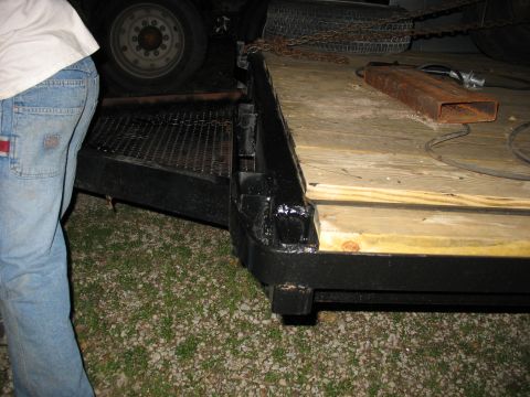 1900 Ford C-350 (Centurion Conversions) - A close-up view of a trailer ramp and a tire, with a person's legs and jeans in the foreground.