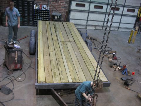 1900 Ford C-350 (Centurion Conversions) - A trailer with a wooden deck and metal frame is shown in a workshop setting.