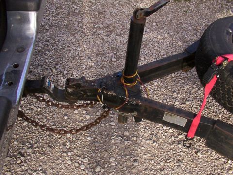 1900 Ford C-350 (Centurion Conversions) - Close-up of a trailer hitch assembly, showing the connection point and safety chains.