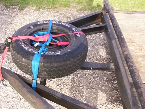 1900 Ford C-350 (Centurion Conversions) - A spare tire is strapped to the frame of a trailer, ready for transport.