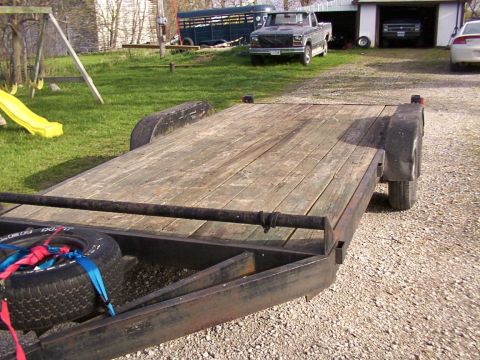 1900 Ford C-350 (Centurion Conversions) - Flatbed trailer in a yard with other vehicles and a playground visible.