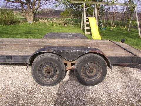 1900 Ford C-350 (Centurion Conversions) - A dual axle trailer sits in a gravel driveway with a swing set and slide visible in the background.