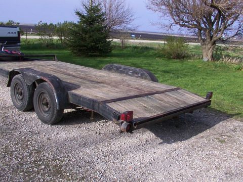 1900 Ford C-350 (Centurion Conversions) - A dual-axle car trailer with a weathered wooden deck sits on a gravel surface.